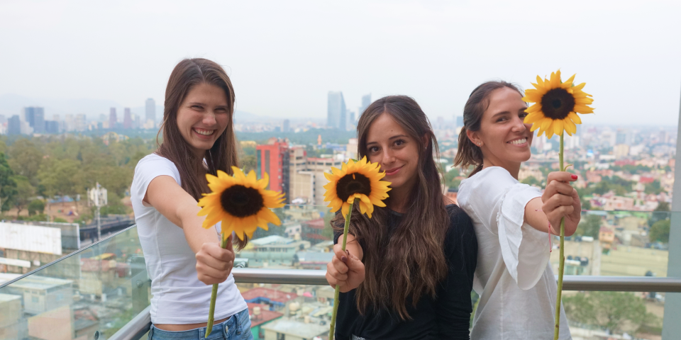Estudiantes sonriendo con girasoles